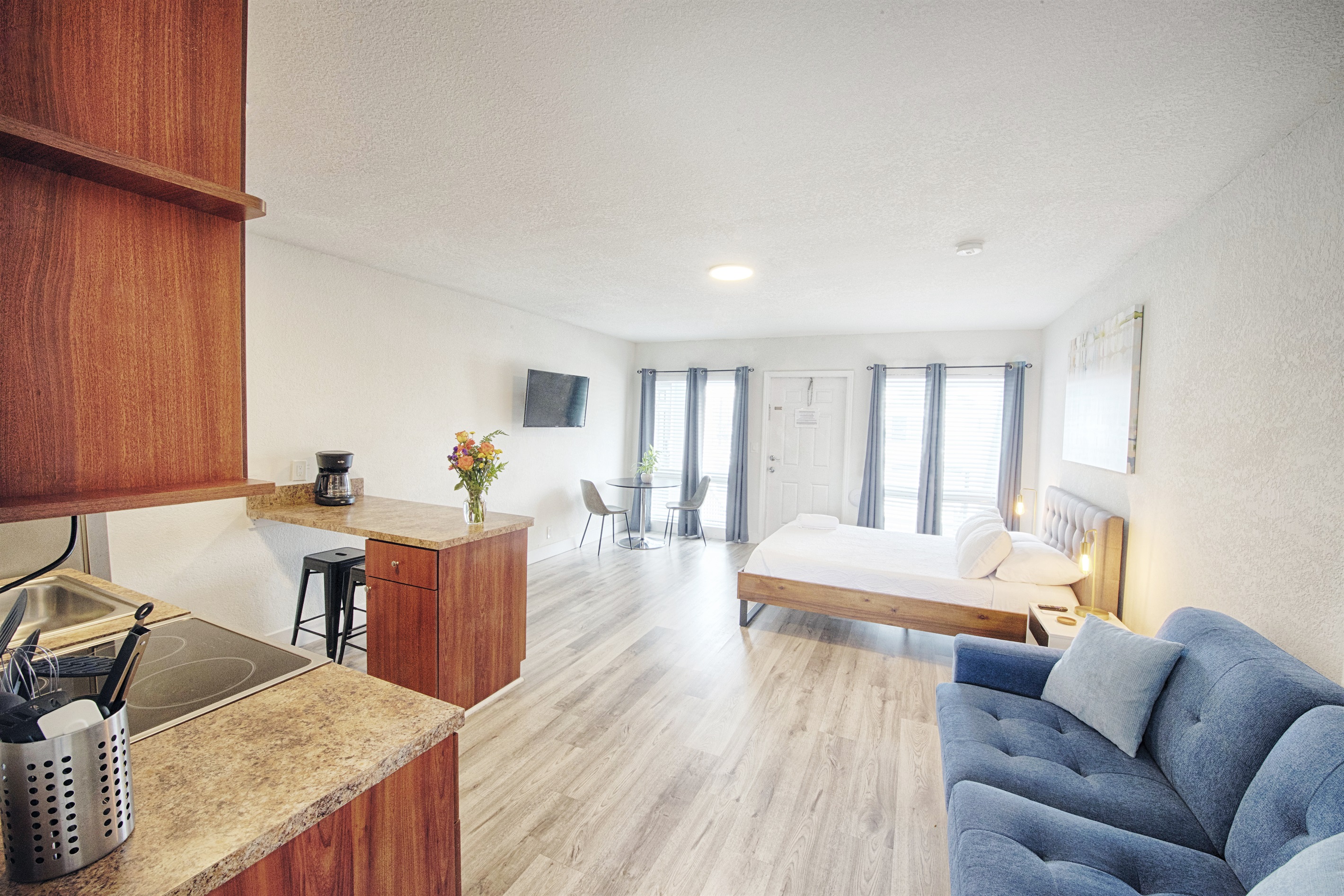 Kitchen with large counter space, and multiple seating options. View of apartment entry.