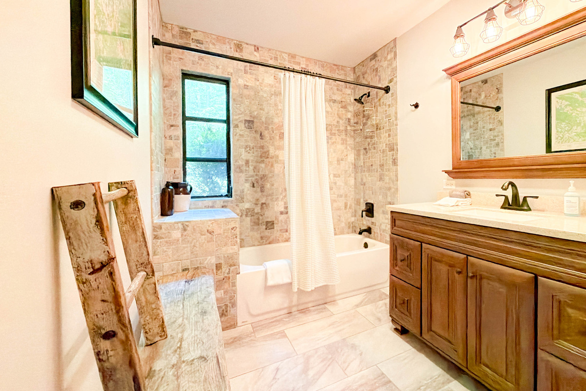 spacious guest bathroom features a tub/shower combo, toilet, and sink.