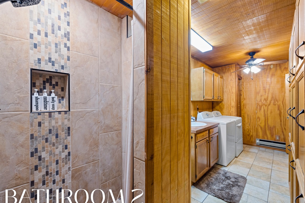 Bathroom with tiled shower and rustic details.