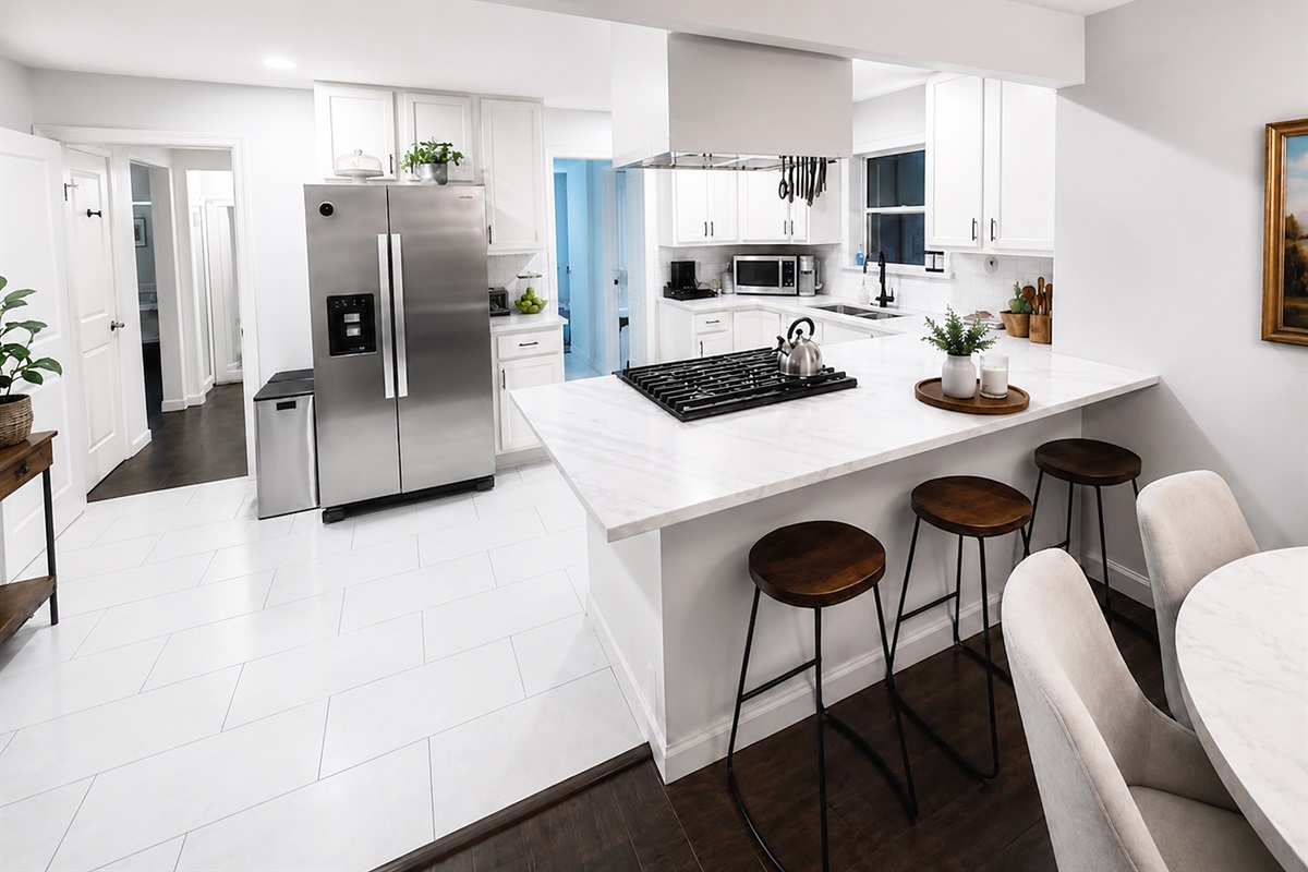 Bright chef’s kitchen featuring quartz countertops, stainless steel appliances, and bar seating for casual dining