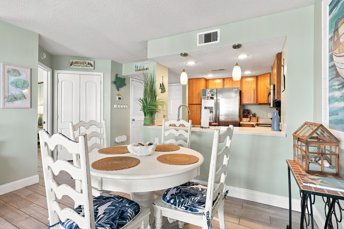 Coastal dining set with seating for four, conveniently located right next to the kitchen and living area.