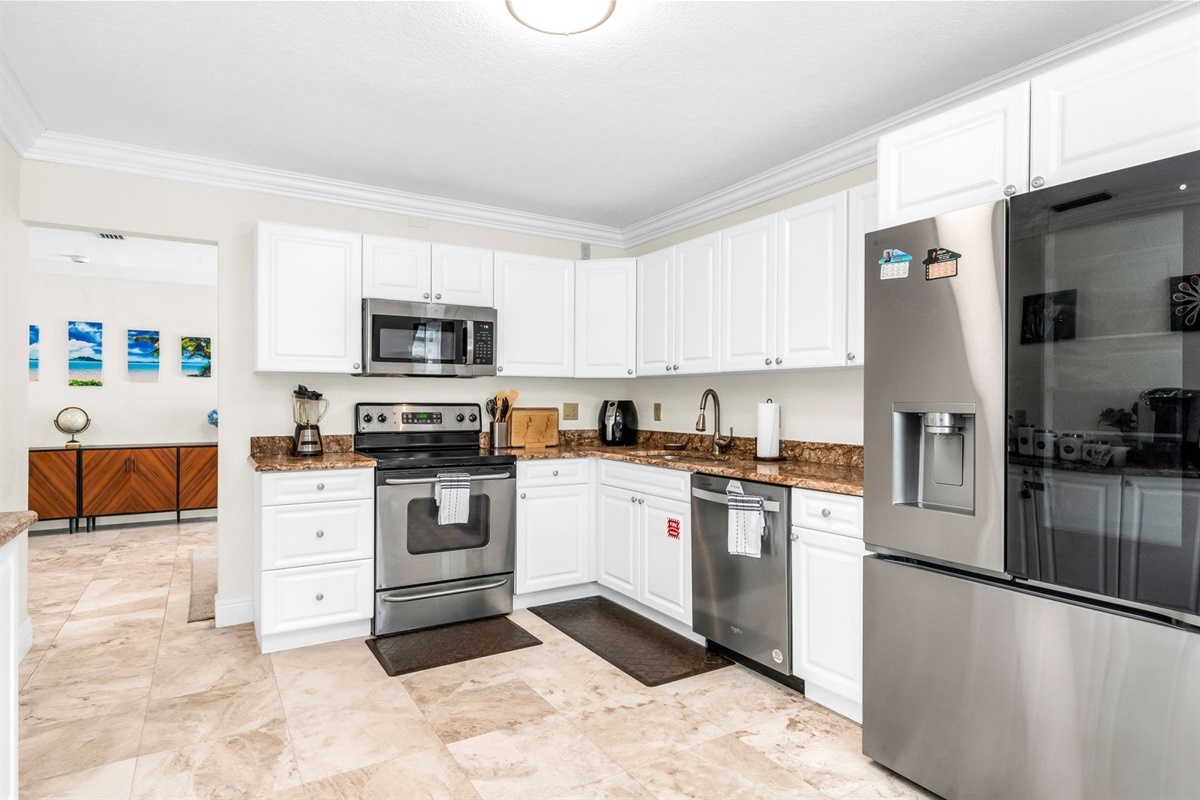 Bright, spacious kitchen featuring full-size stainless appliances, a dedicated coffee bar, and a bonus dining area with seating for four—perfect for families and groups.