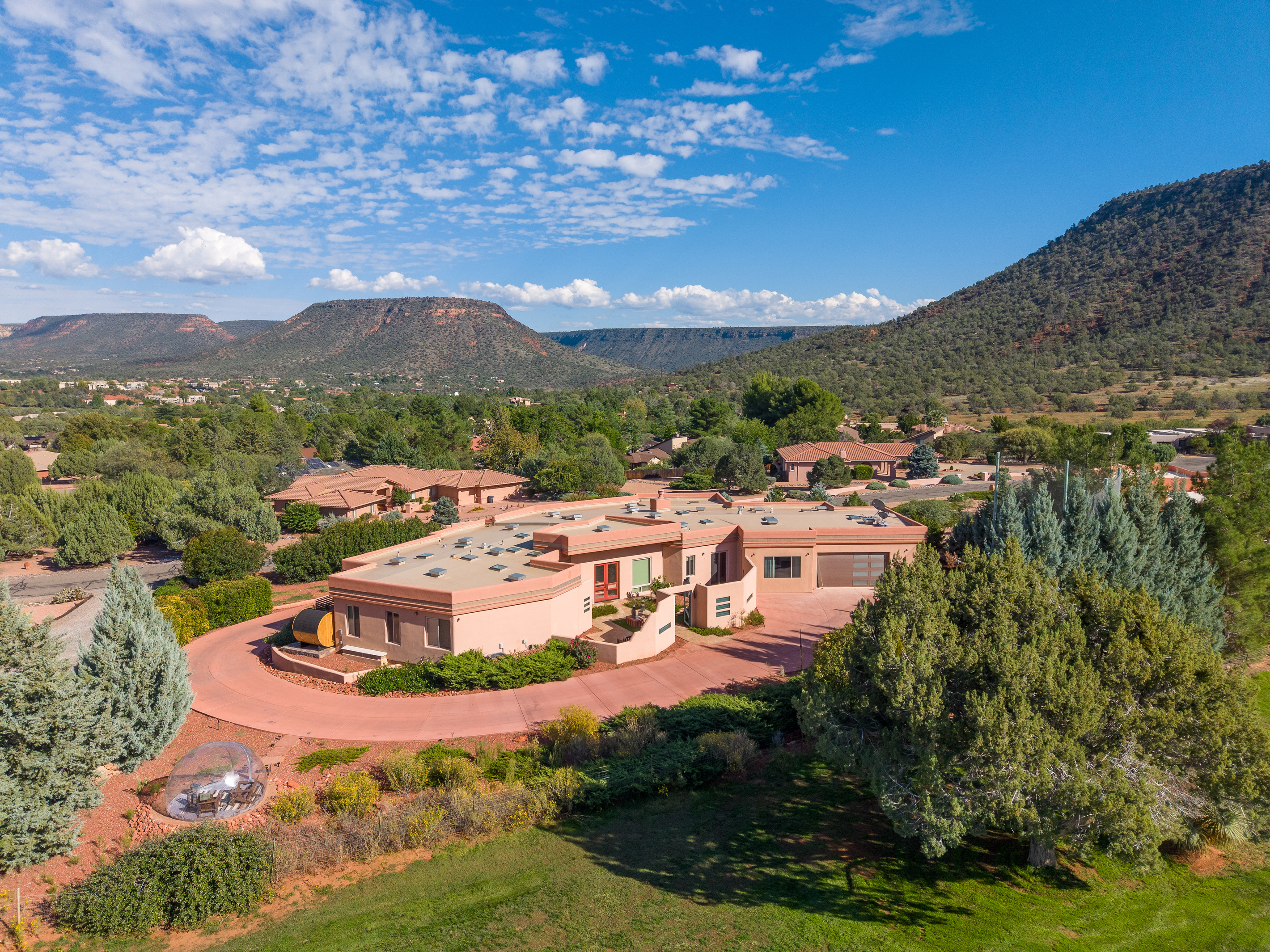 Private luxury retreat with circular drive, lush golf course frontage, outdoor barrel sauna, and a cozy stargazing dome.