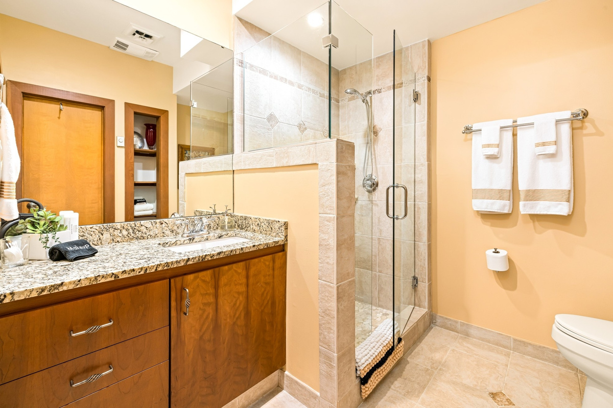 3/4 bath with glass walk-in shower features artisan bath soap, numerouos wash clothes and towels for your stay.
