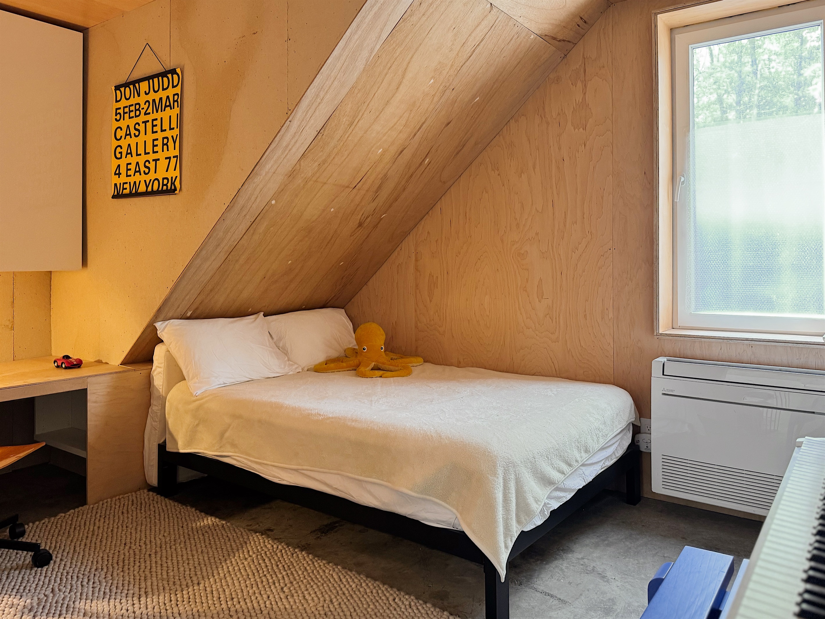 Smaller downstairs bedroom with digital piano, kid-height desk, and kids books.