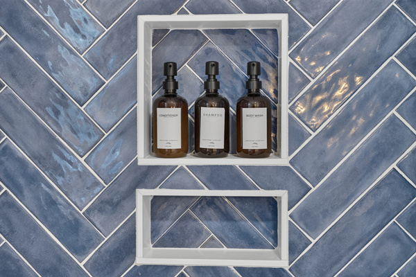 Beautiful walk-in shower featuring stylish tile and a built-in niche for toiletries.