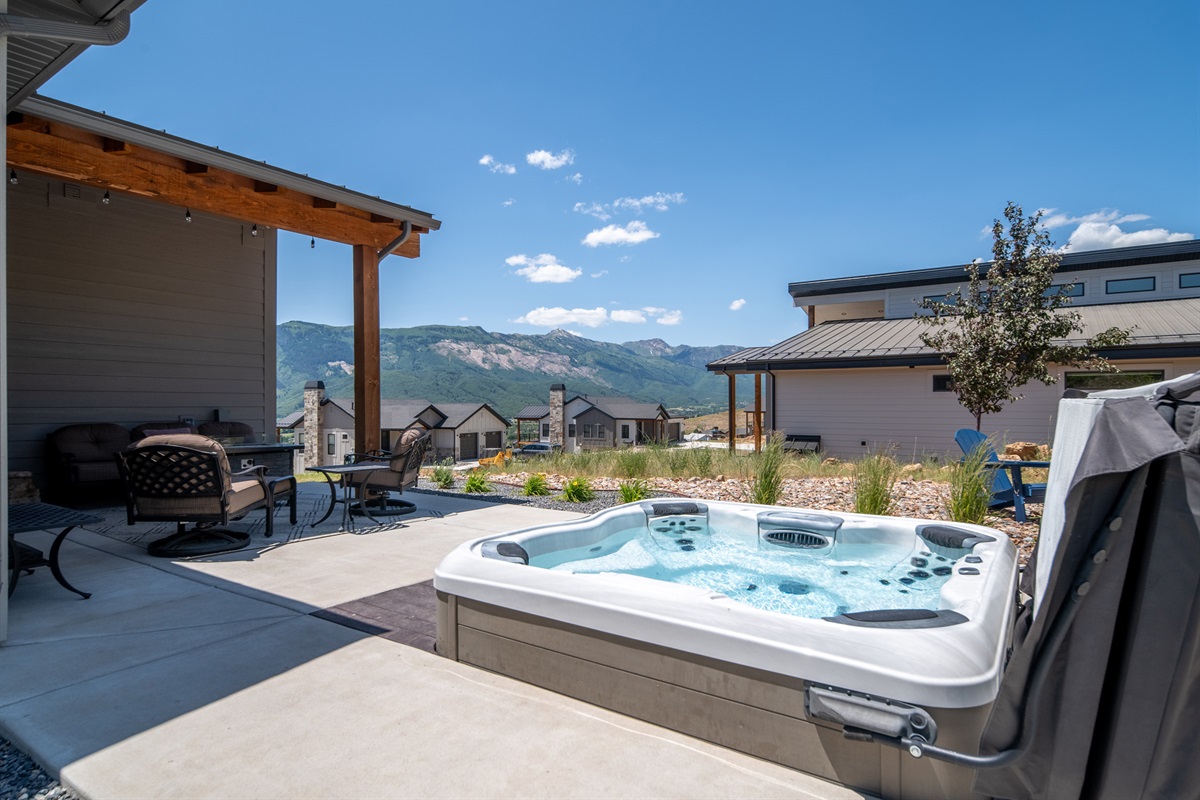 Relax in the private hot tub while taking in the surrounding mountain scenery