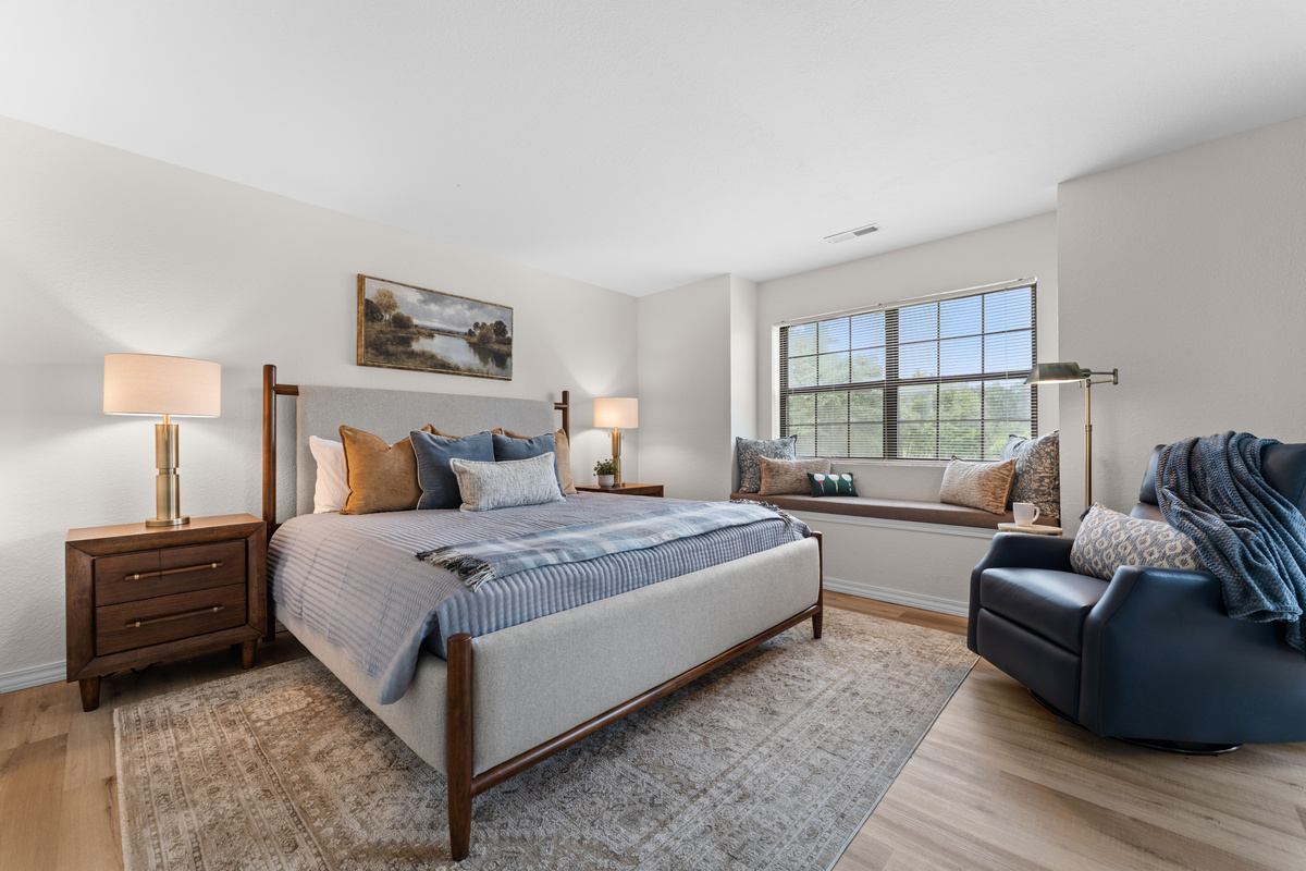 The spacious primary bedroom features a king bed, room-darkening curtains, a reading chair, and a built-in window seat.