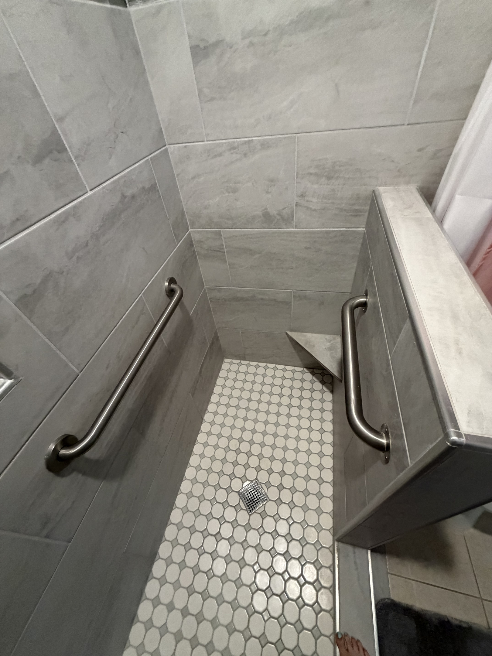 This photo provides a view looking from the front of the shower. Highlighting the layout and accessibility of the space.