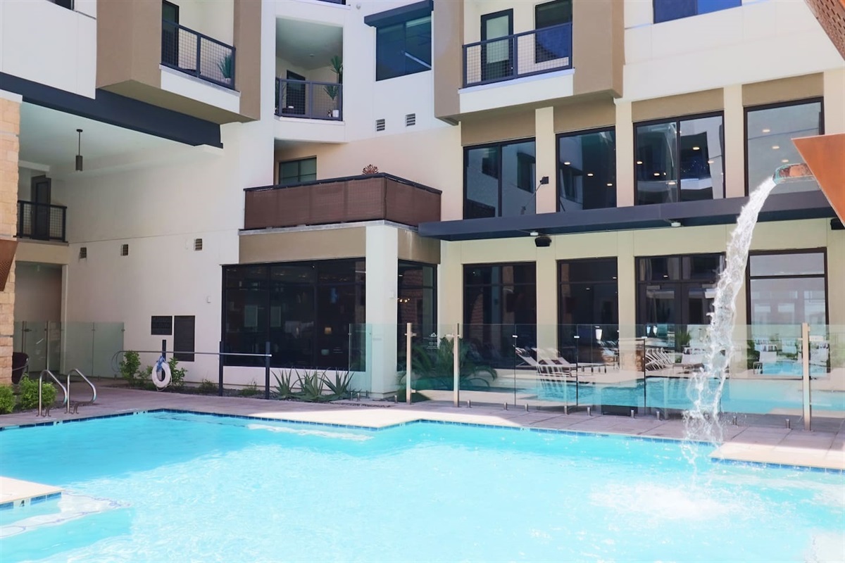 - Dive into a sparkling pool with cascading water features and sunny views   - Surrounded by modern architecture and inviting outdoor lounge seating   - A refreshing retreat to relax, swim, and enjoy peaceful summer moments