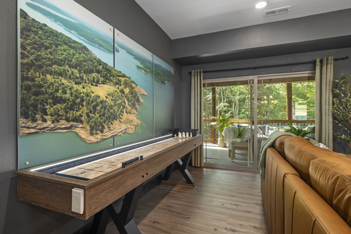 Slide a round on the shuffleboard table beneath a sweeping lake-shore mural.