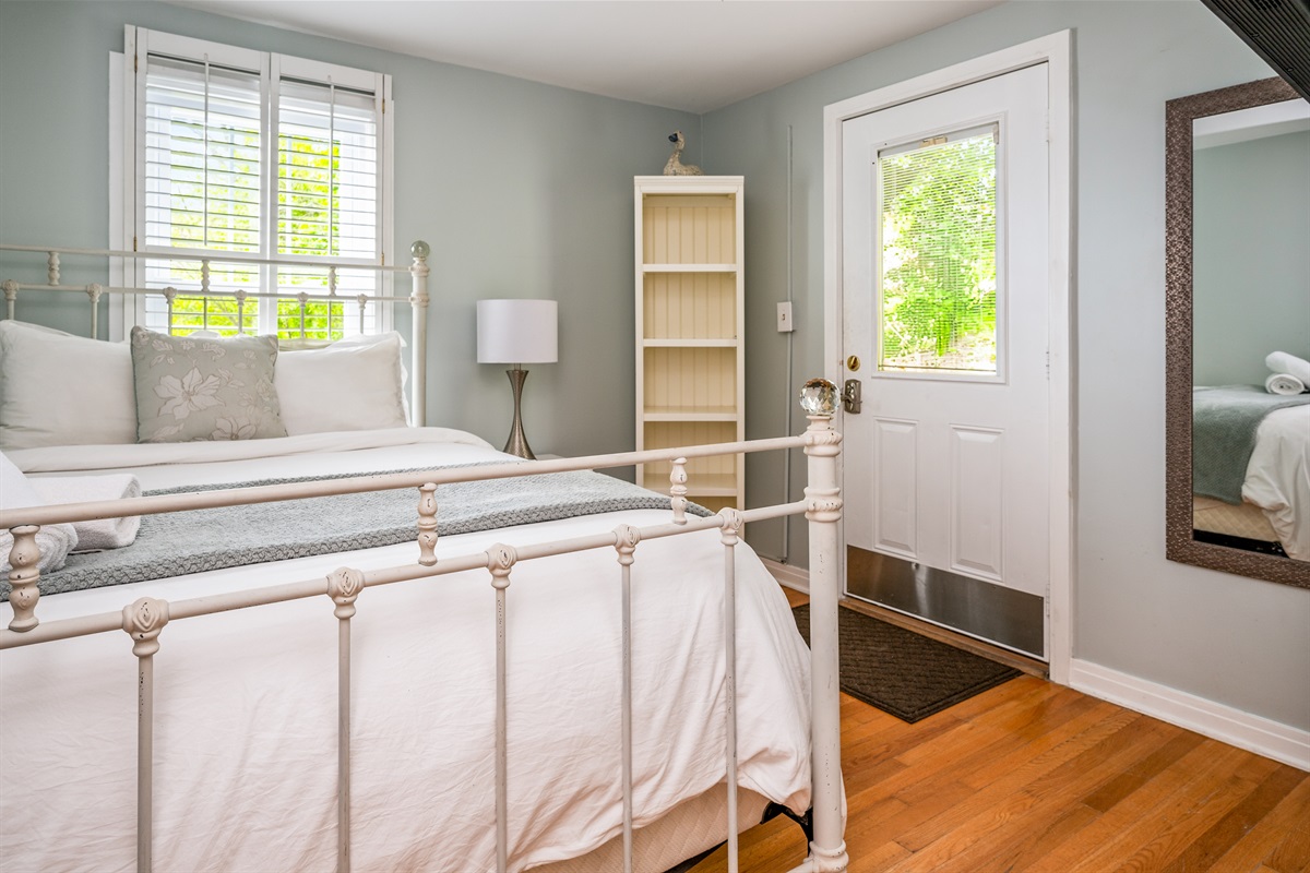 Relax in this serene bedroom with soft natural light, plush bedding, and direct outdoor access 🌿🛏️🚪