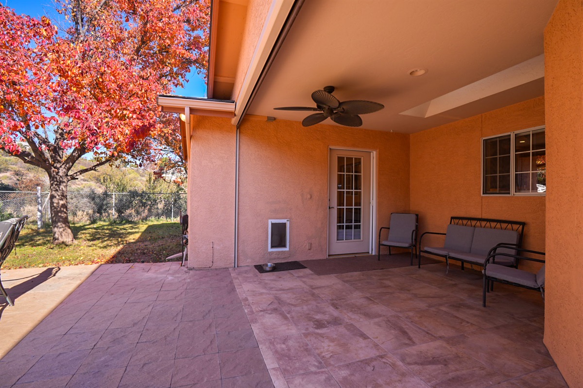 Covered patio with seating and direct backyard access—perfect for relaxing and great for traveling with pets