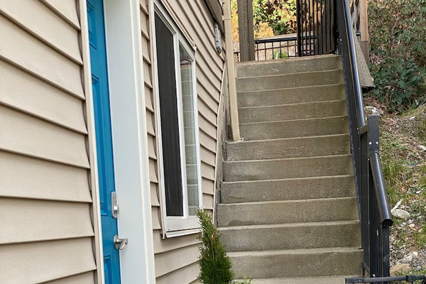 Looking down the sidewalk to the door to the suite in the left.