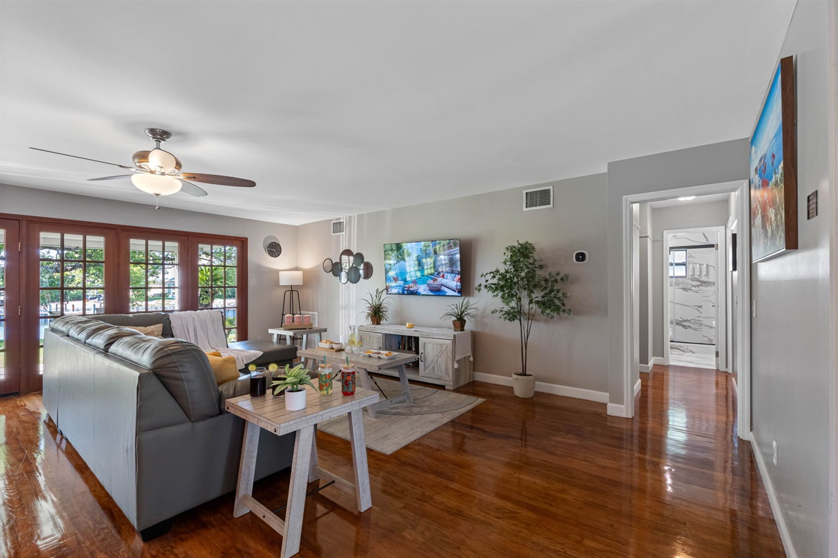 The abundance of glass doors allows sunlight to stream through, highlighting the rich wood floors and soft gray walls.