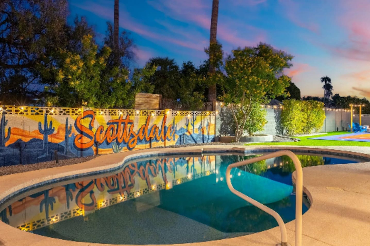 As the sun sets, the pool glows under string lights with a hand-painted Scottsdale mural setting the backdrop for evening swims.