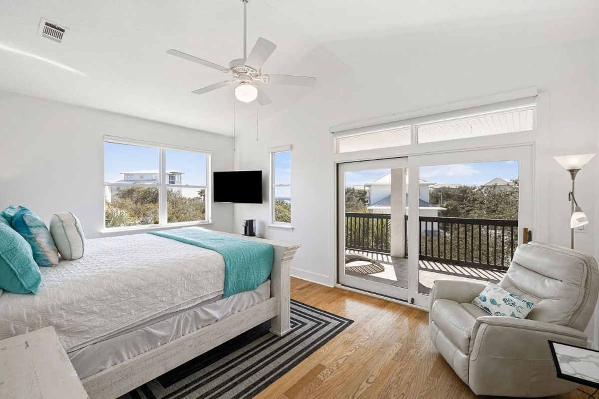 Expansive primary King bedroom designed for ultimate relaxation, offering abundant natural light, comfortable seating, and a private outdoor balcony