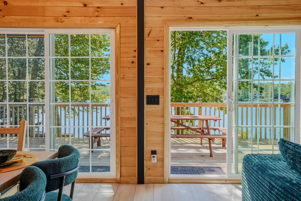 Main floor entry with sliding door open to the upper deck and lake beyond
