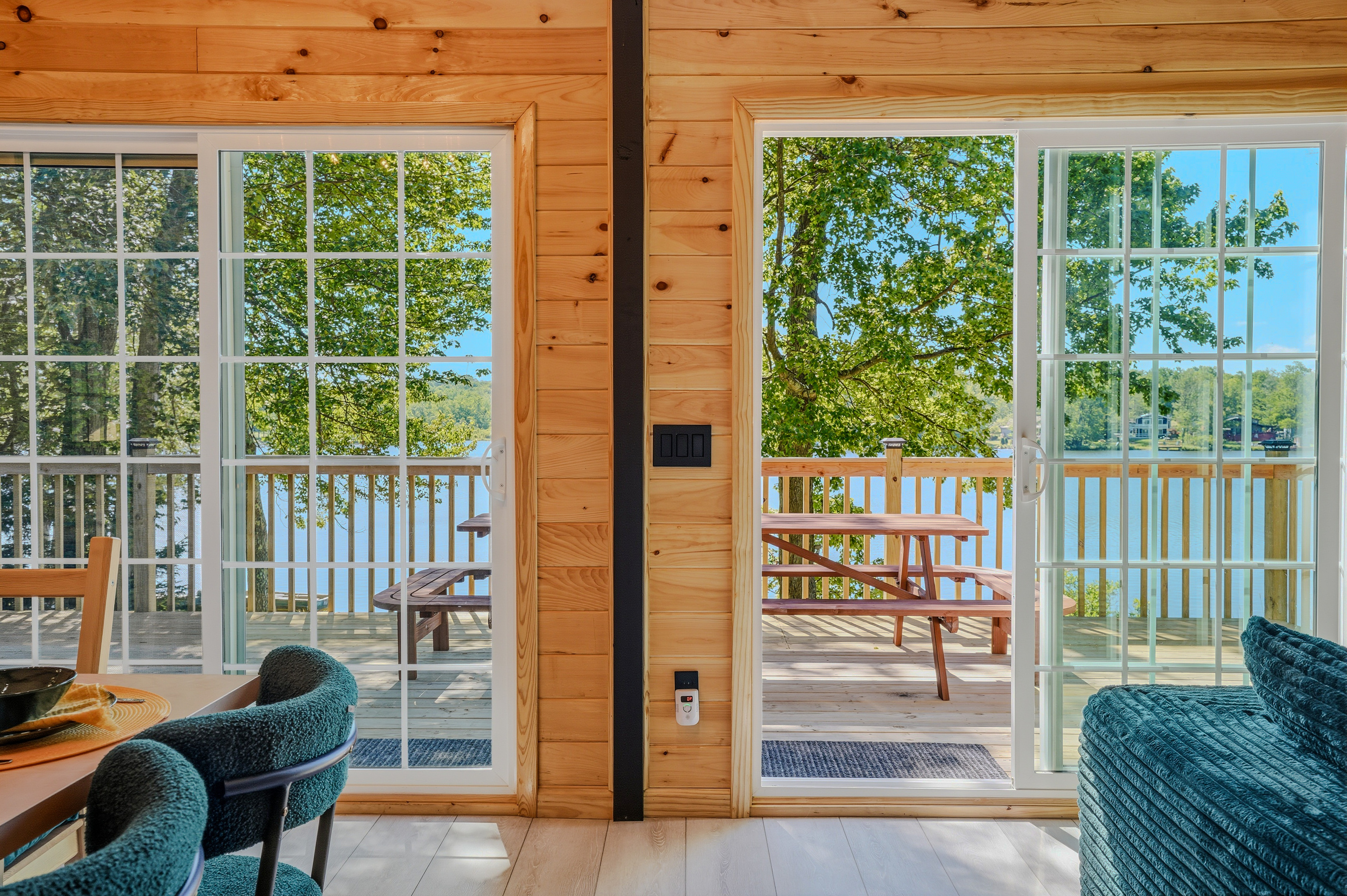 Main floor entry with sliding door open to the upper deck and lake beyond