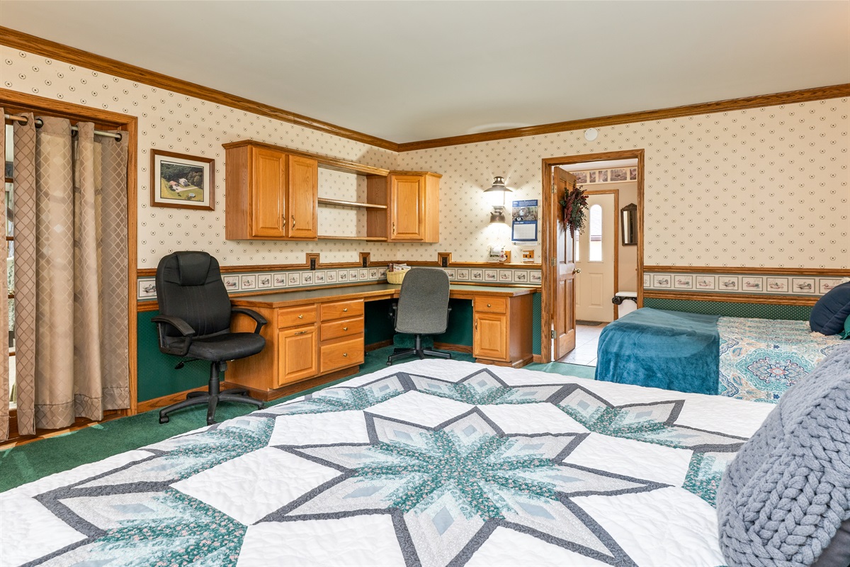 Main floor king bedroom with additional double bed and desk for remote work