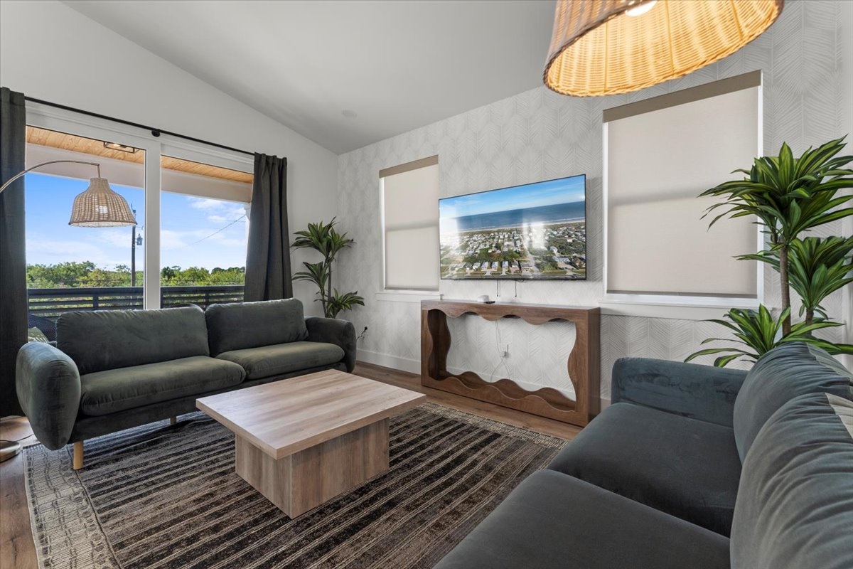 Bright and inviting living room featuring modern furnishings, large windows, and an open layout.