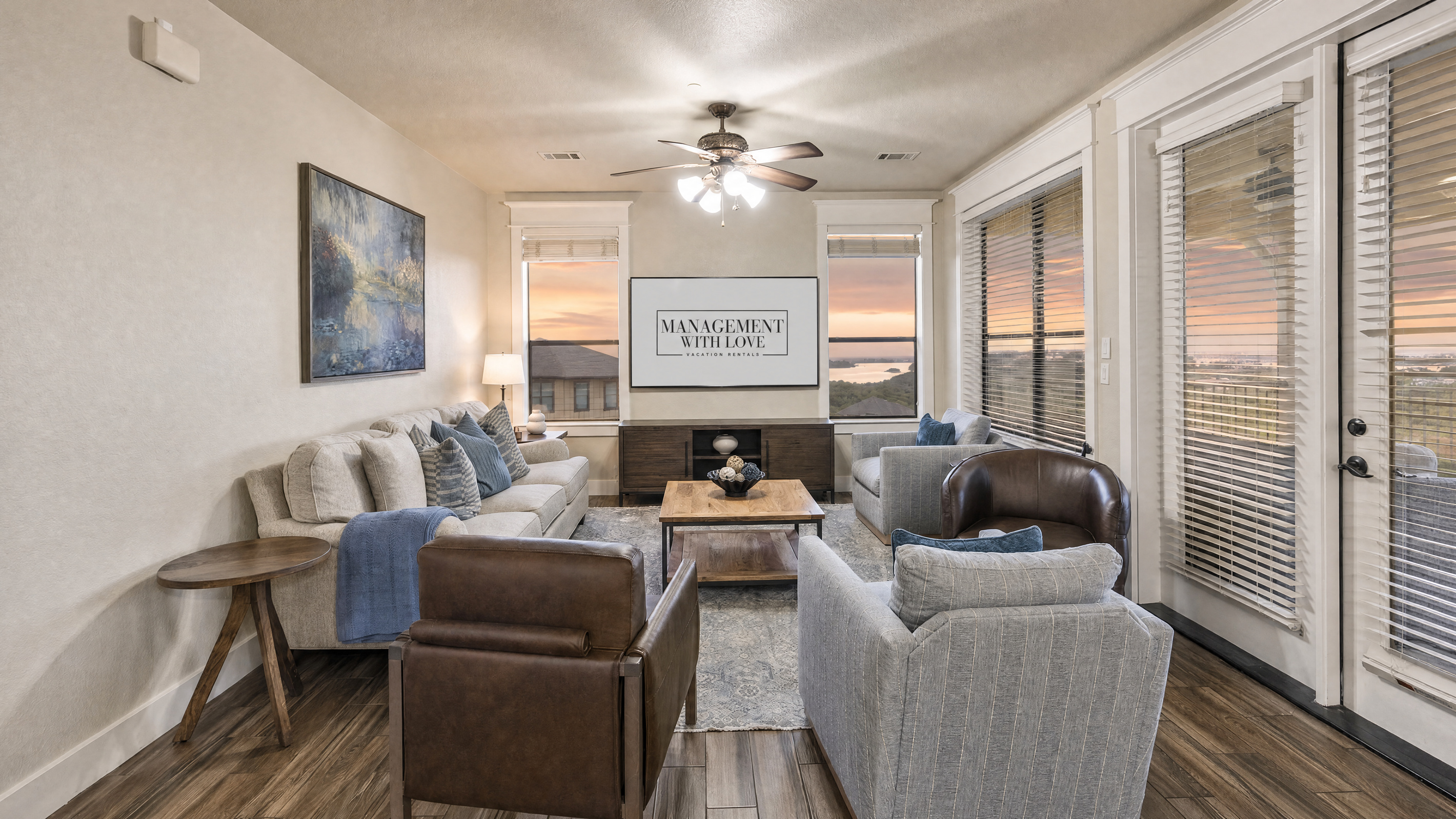Open living area with comfortable seating, TV, and large windows overlooking Lake Travis. The living room opens directly to the covered balcony.