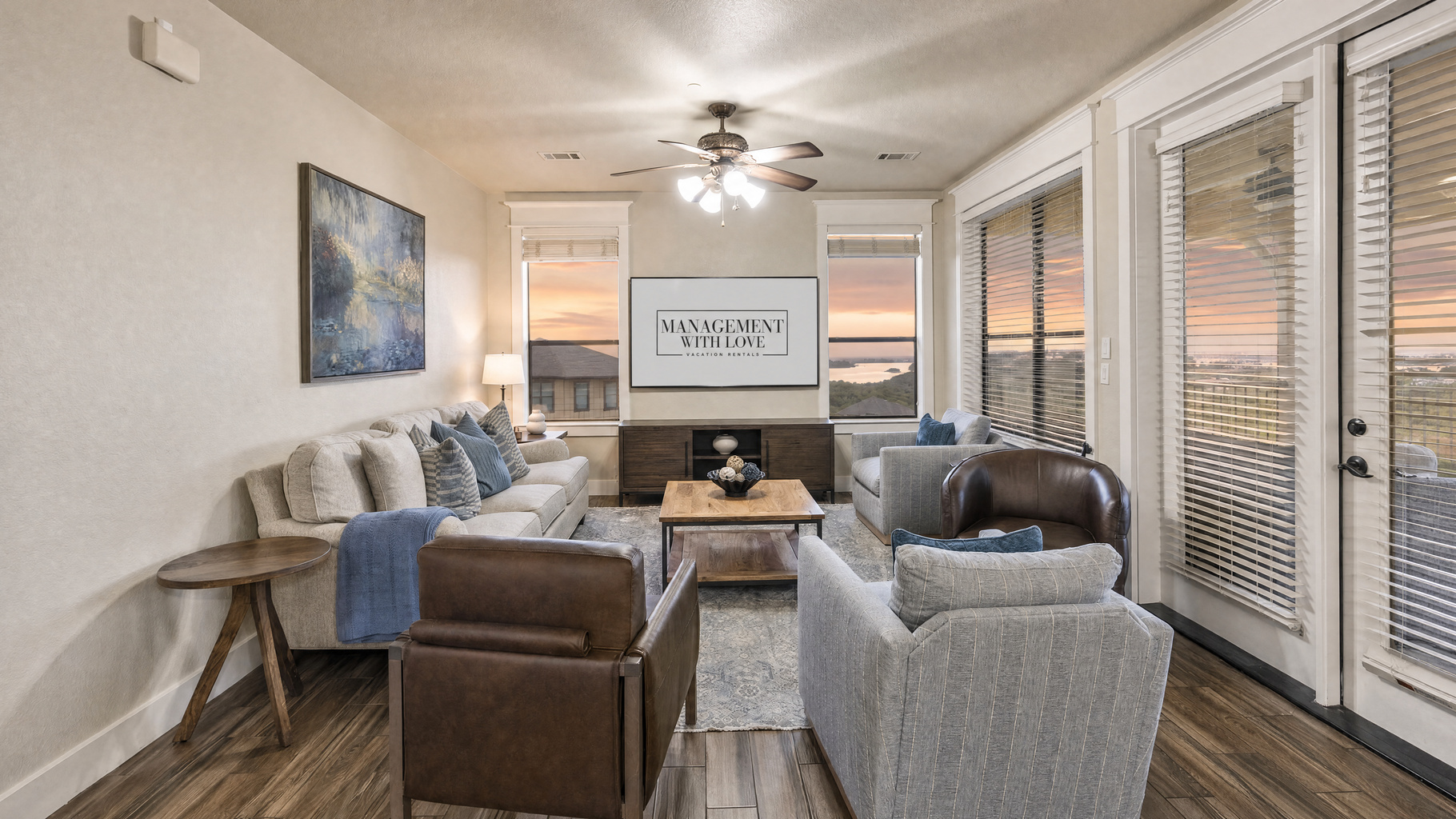 Open living area with comfortable seating, TV, and large windows overlooking Lake Travis. The living room opens directly to the covered balcony.