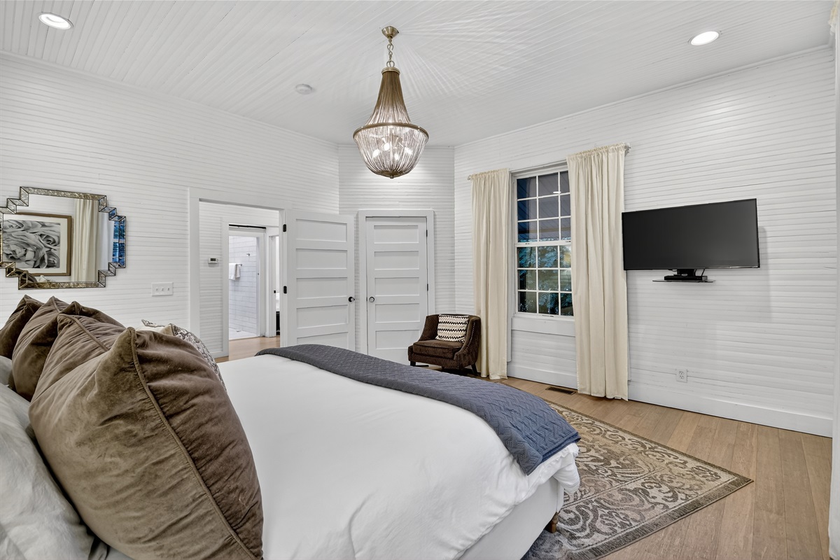Unwind in this dreamy bedroom with plush bedding, soft lighting, and peaceful vibes. A restful space designed for cozy nights and slow mornings in Blue Ridge.