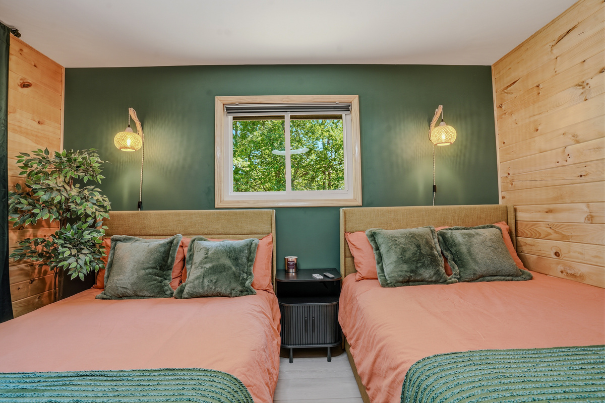 Fifth bedroom alternate angle — warm tones, layered bedding, and natural wood walls