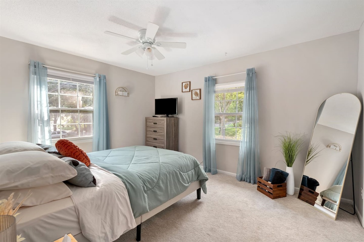 This peaceful bedroom includes soft lighting, and cozy bedding — ideal for work, rest, or creative moments.