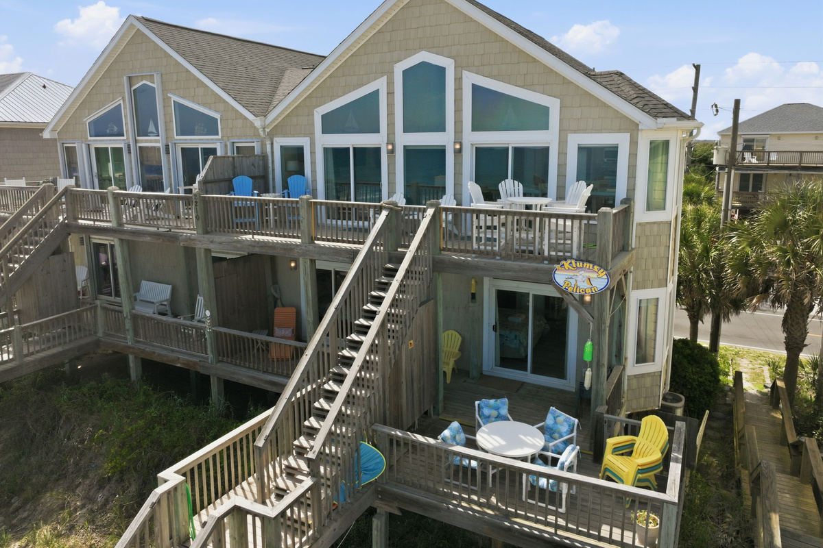 Front exterior of oceanfront beach house with multiple decks and staircase access