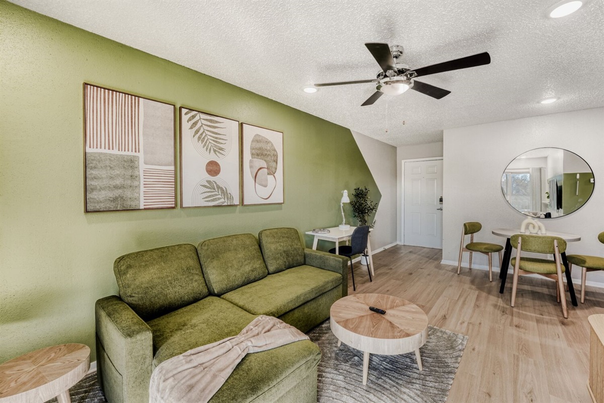 Stylish living room with green accents, modern furniture, and warm wood flooring.