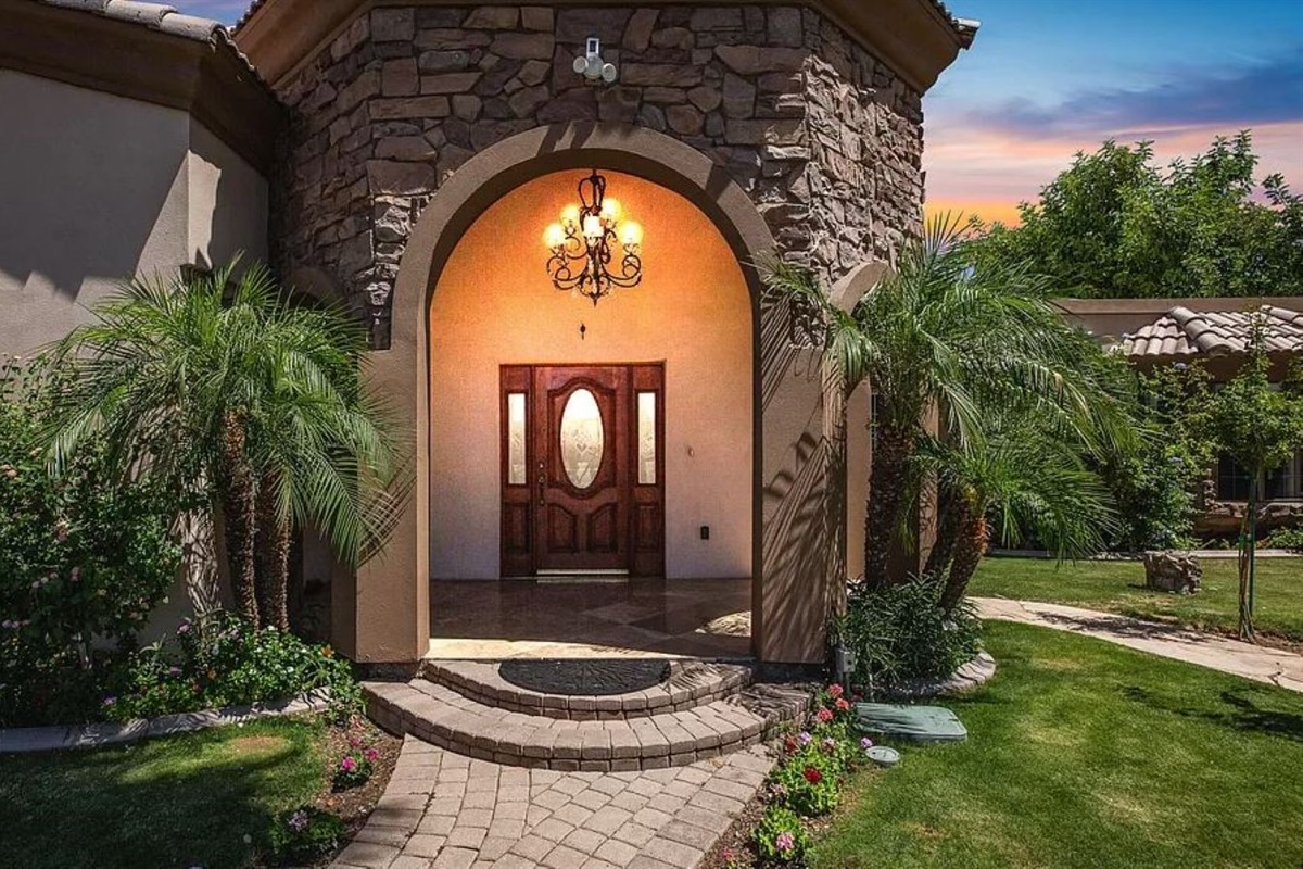 Make a grand entrance into your serene retreat, where lush landscaping, elegant stonework, and warm lighting set the tone for a relaxing stay.