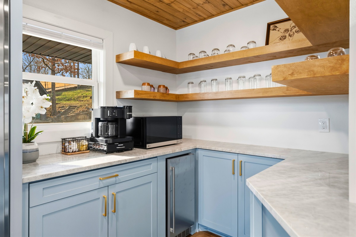 Open shelving and bright finishes add a fresh, inviting touch to the kitchen while keeping everyday essentials within easy reach.