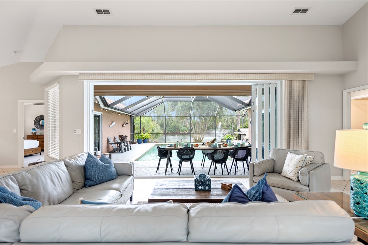 Open the door to paradise—panoramic pool and lake views from the living room