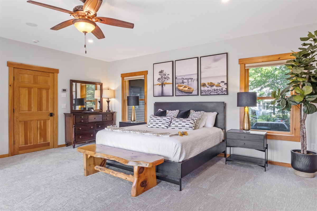 First floor master bedroom ensuite with king and twin beds overlooking Lake Winnipesaukee with hot tub on outside deck.