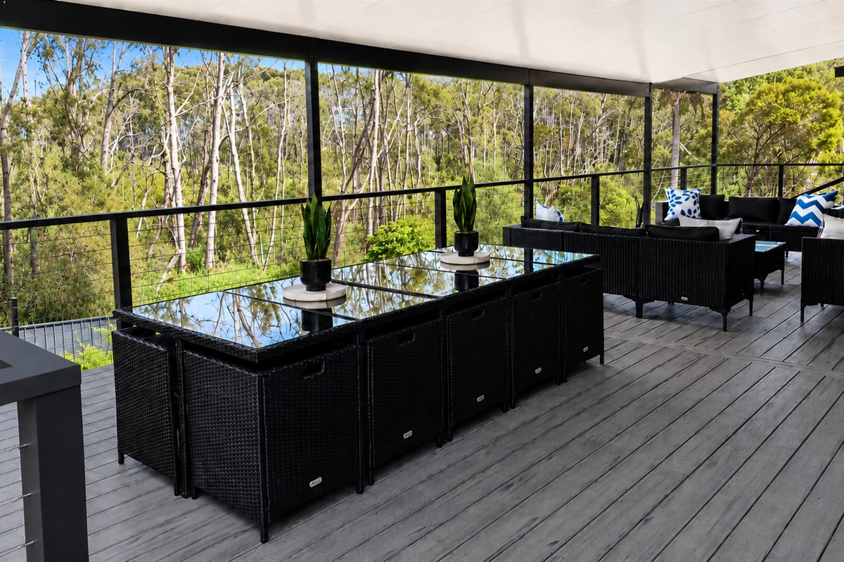 A view across the upper back deck at Skye&rsquo;s Beach House Malua Bay, looking out to the natural backdrop behind the property.