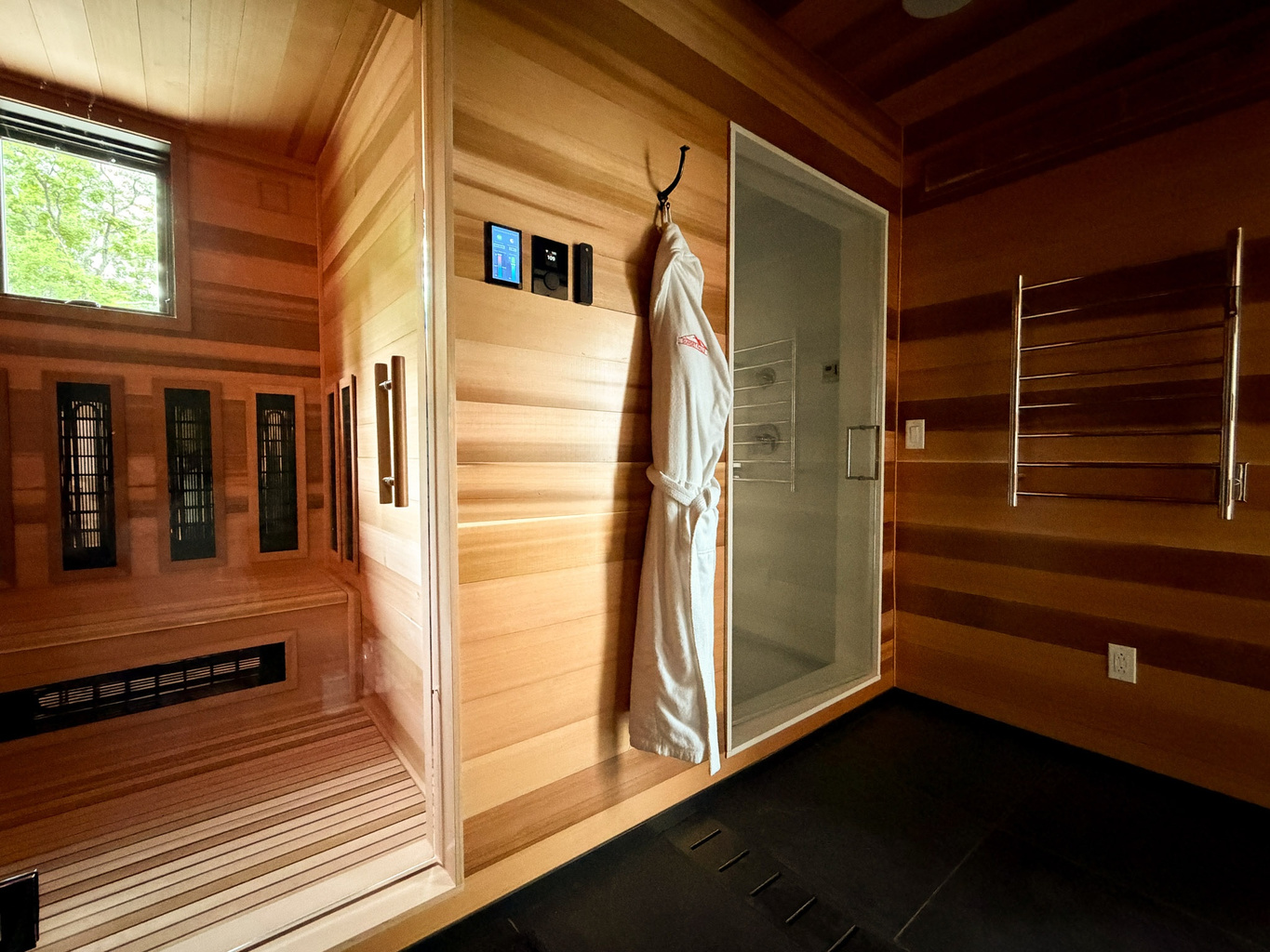 Cedar spa suite at Sunset Falls &mdash; the infrared sauna and steam room doors side by side, robe and heated towel rail between &mdash; Berkshires