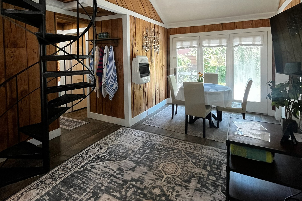 Living room with spiral staircase leading to loft bedroom.