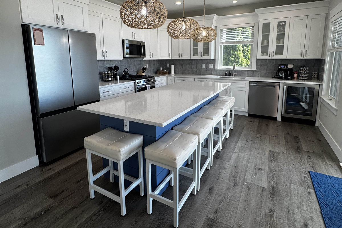 Bright, modern kitchen with a large island, bar seating, stainless steel appliances, and stylish pendant lighting—perfect for cooking and entertaining.