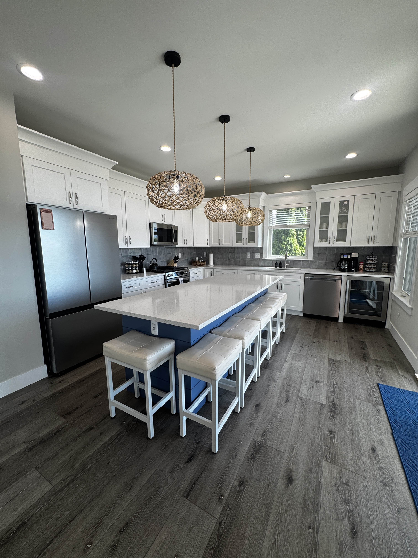 Bright, modern kitchen with a large island, bar seating, stainless steel appliances, and stylish pendant lighting—perfect for cooking and entertaining.