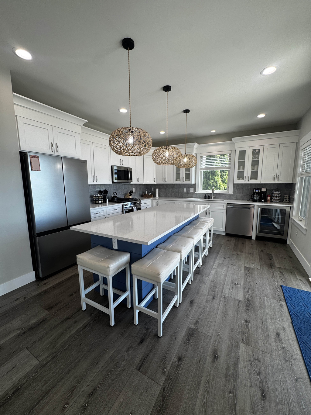 Bright, modern kitchen with a large island, bar seating, stainless steel appliances, and stylish pendant lighting—perfect for cooking and entertaining.