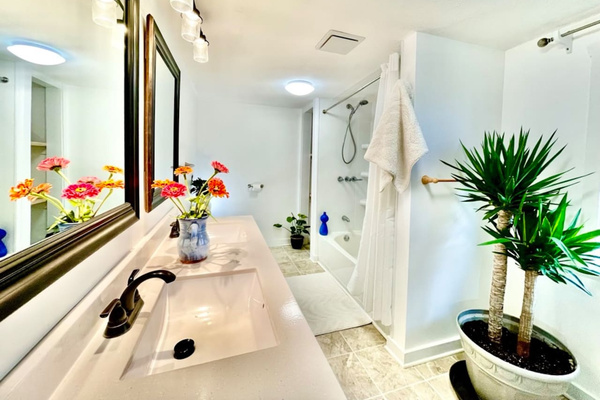 Tile floor bathroom with double sinks and tub. Two person infrared sauna (to ther right and not pictured).