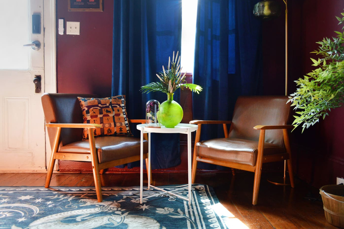 Sunlit reading nook with mid-century chairs and vintage décor inside this historic New  Orleans Airbnb. A cozy spot to sip coffee, relax, or recharge before exploring Bourbon Street and Frenchmen Street. 