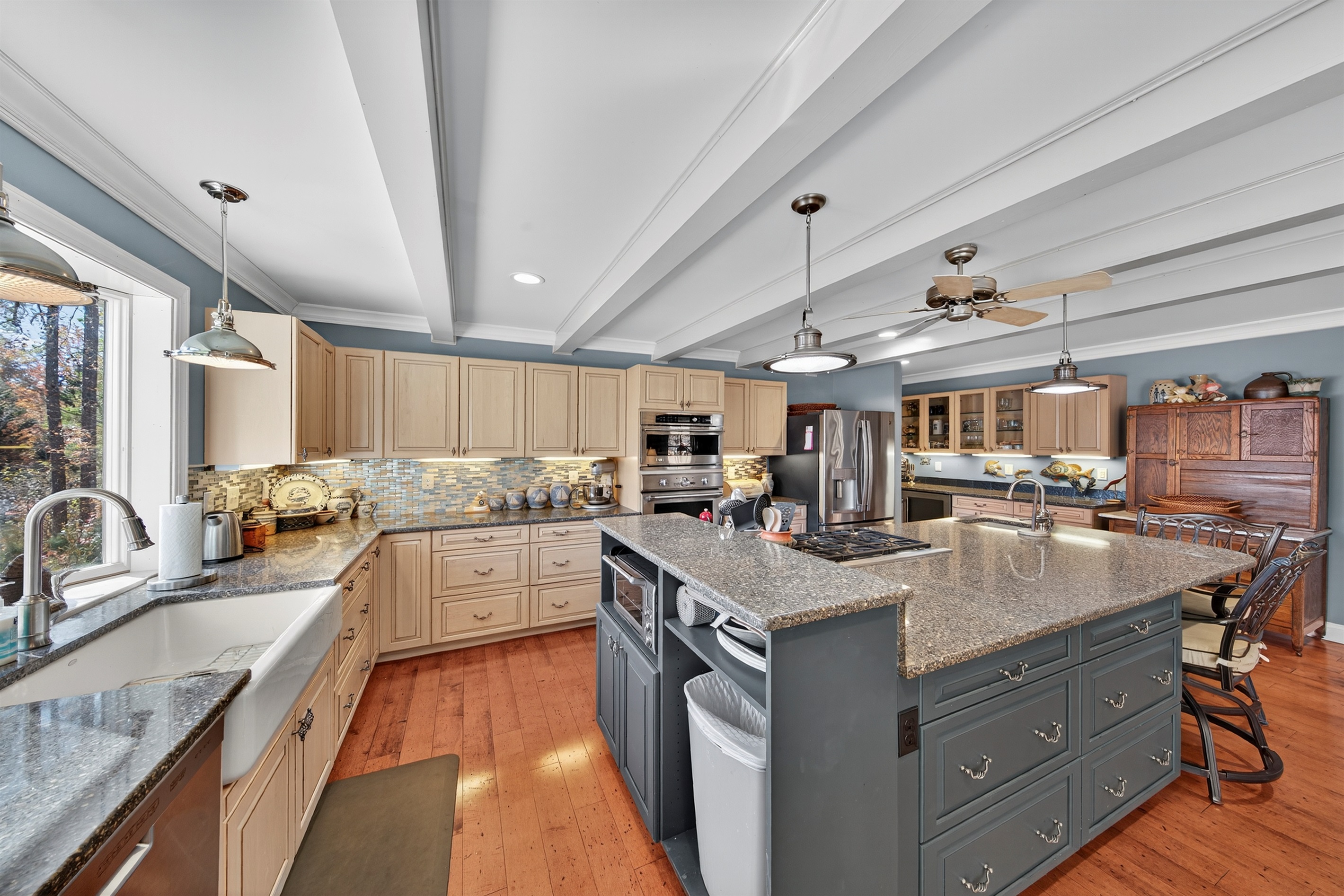 A standout kitchen with exposed beams, a massive central island, and thoughtfully designed storage for effortless cooking and entertaining.