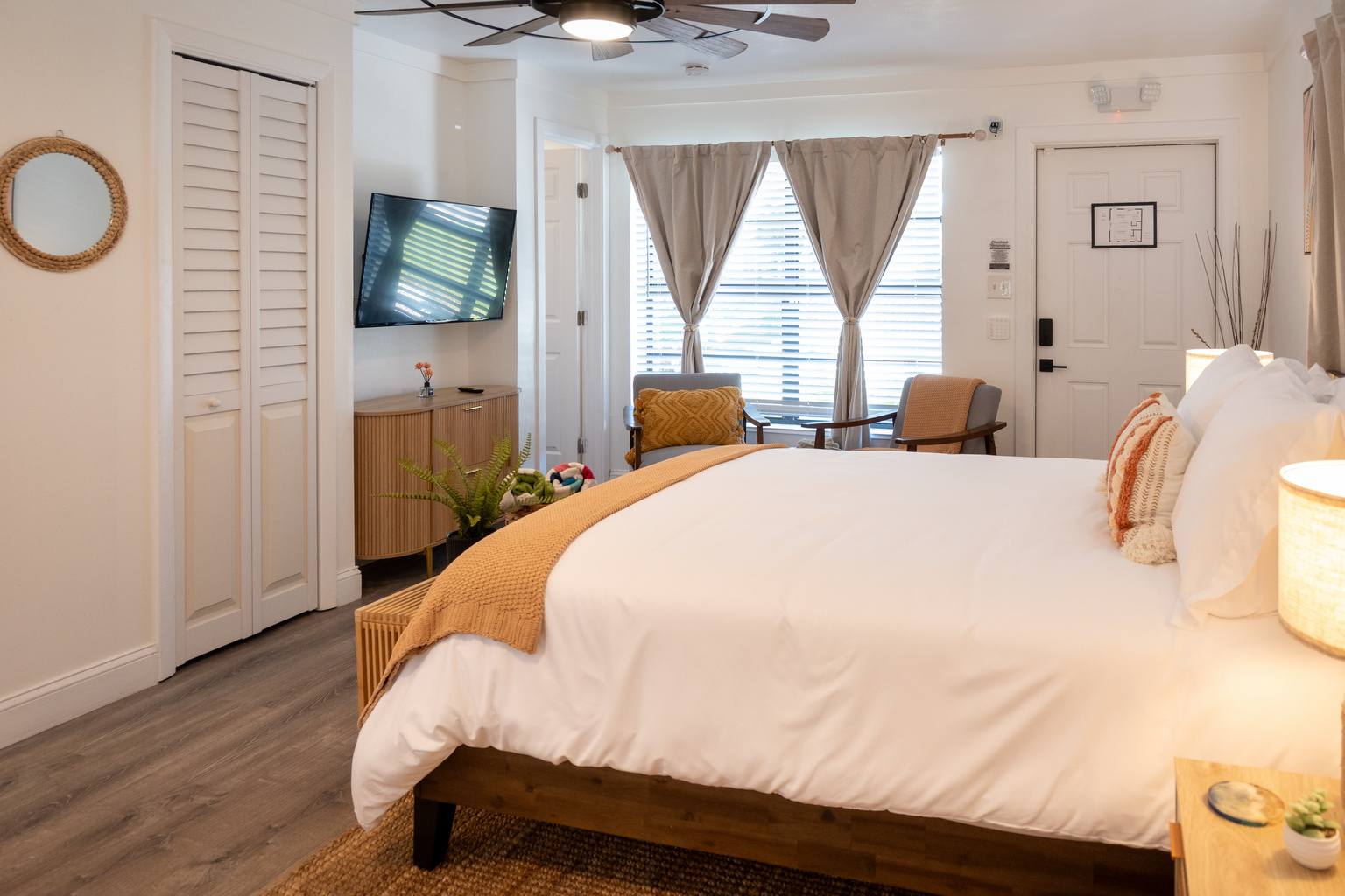Queen bed facing the Smart TV, with a reading chair by the window