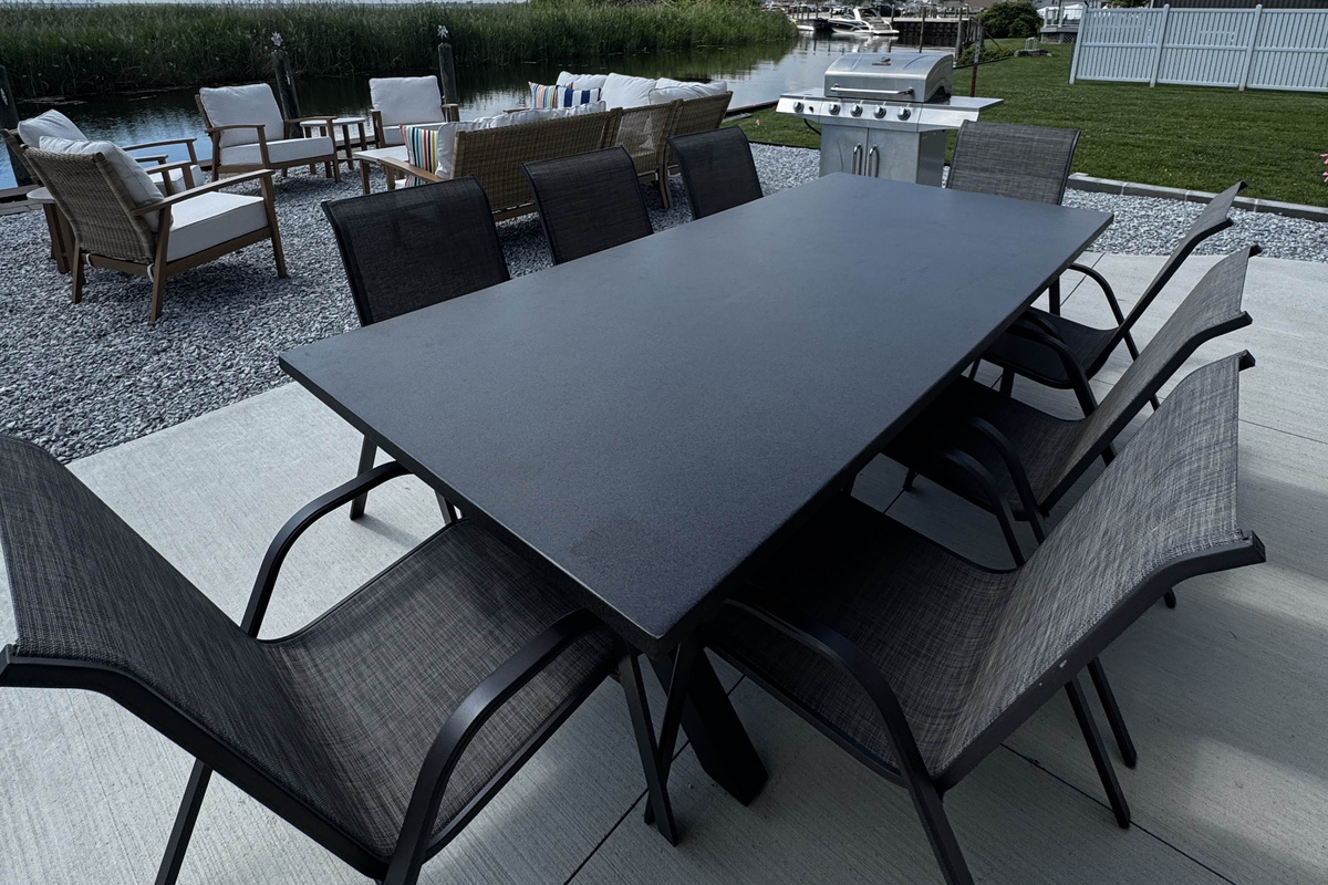 Sleek outdoor dining table with modern chairs—perfect for entertaining on the waterfront patio.