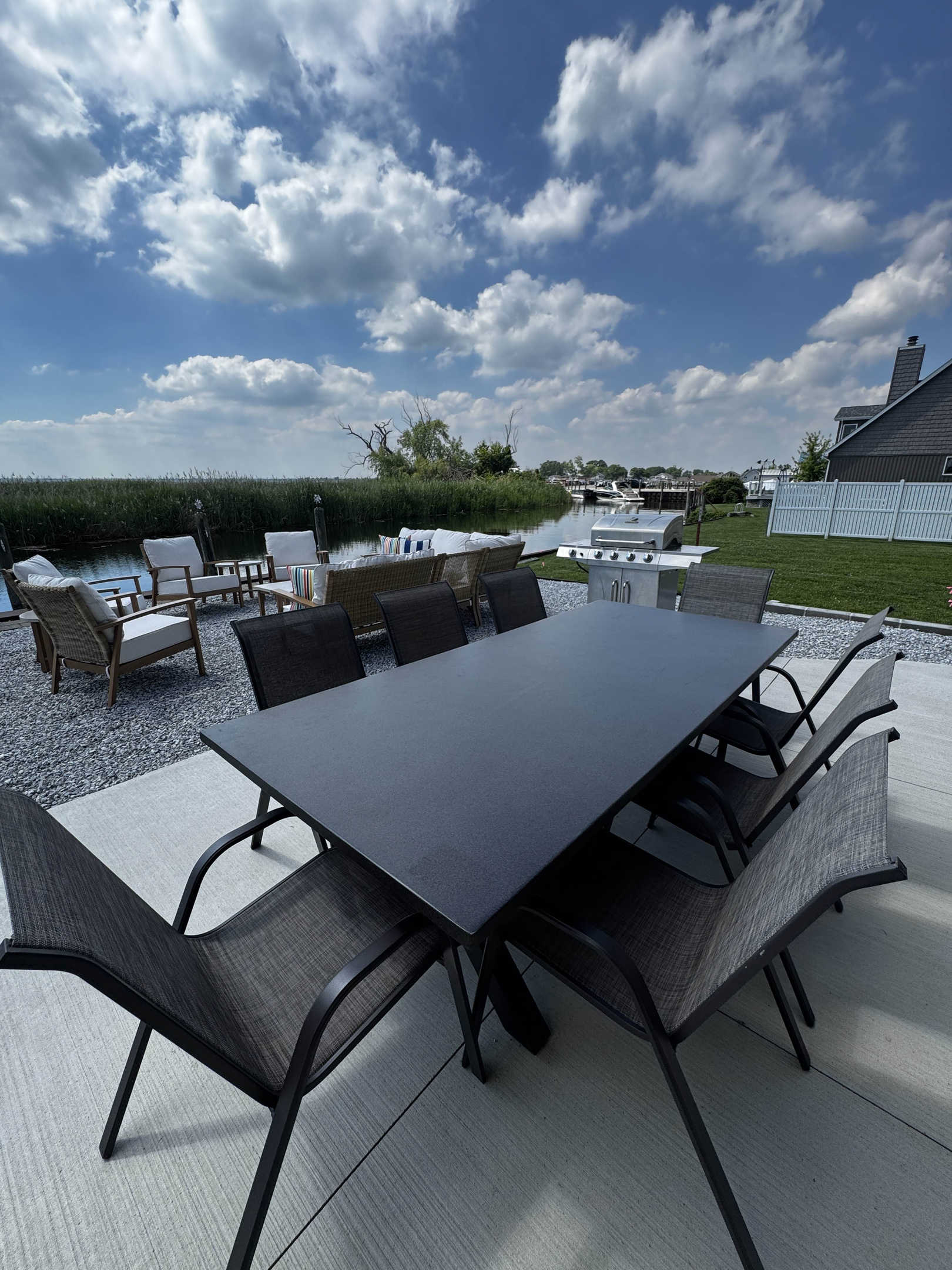 Sleek outdoor dining table with modern chairs—perfect for entertaining on the waterfront patio.