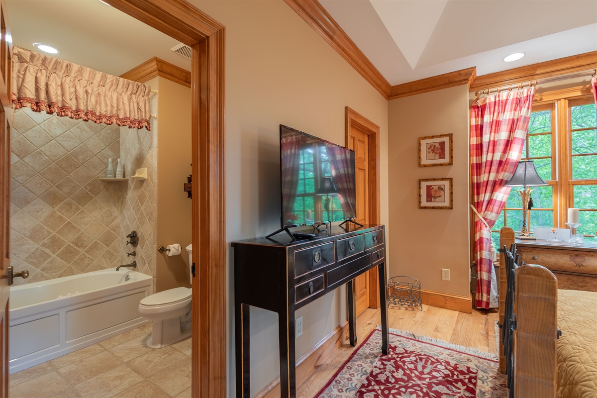 Conveniently located just off the bedroom, the shared en suite bathroom features a jetted tub/shower combo and warm, rustic finishes throughout.