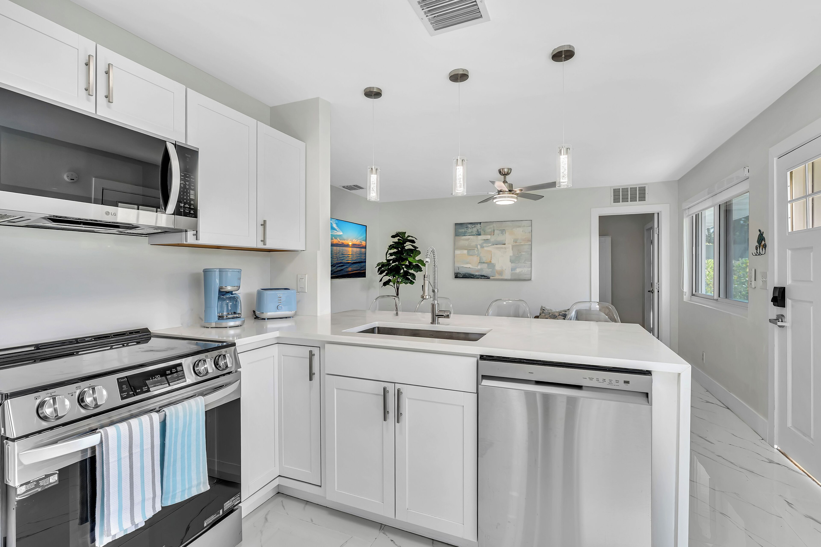 Modern kitchen featuring premium LG stainless steel  appliances, quartz countertops and bar seating.
